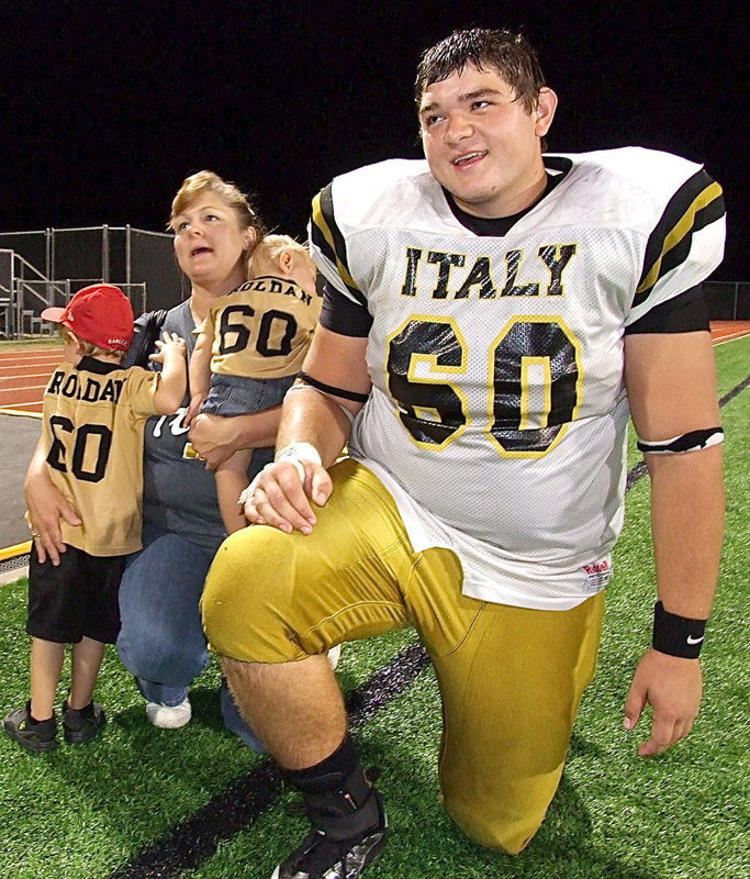 Image: Senior kicker, punter, offensive tackle and defensive tackle Kevin Roldan(60) has quite the fan following as mother Flossie Gowin tries to get a handle on all the sixty’s.