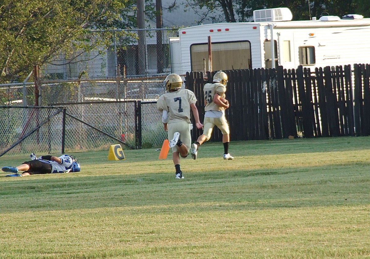 Image: Kyle Tindol(25) goes the distance for his first touchdown wearing Gladiator Gold as teammate Gary Escamilla(7) hustles down to celebrate with his fellow 8th Grader.