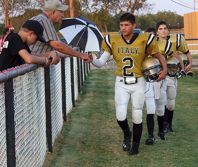 Image: Here they come! Joe Celis is greeted Mr. Richard Cook as the JV Gladiators take the field.