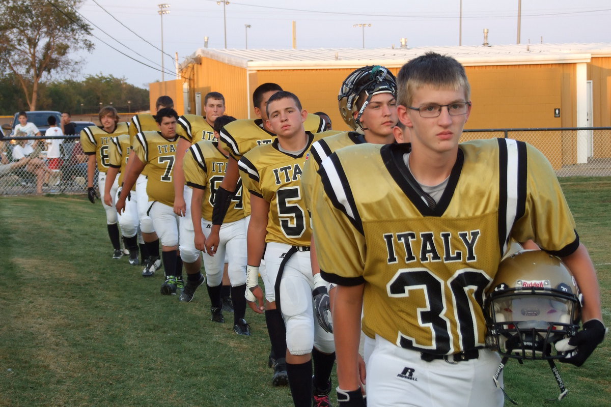 Image: Hunter Ballard(30), Colton Grant(40) and Austin Crawford(56) help lead the JV Gladiator march onto Willis Field.