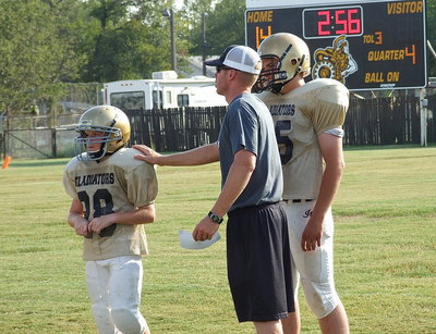 Image: Coach Jon Cady sends in Garrett Cash(28) with a play as Wesley Helms(65) offers advice.
