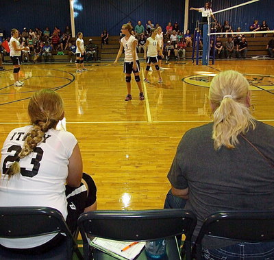 Image: Granddaughter, Brycelen Richards(23), takes a break while grandmother, Rita Garza, keeps the game book as Paige Cunningham(1), Kirsten Viator(11), Annie Perry(13), Sydney Weeks(26) and Brianna Hall (38) hold their ground while Emmy Cunningham(27) serves from off the frame.