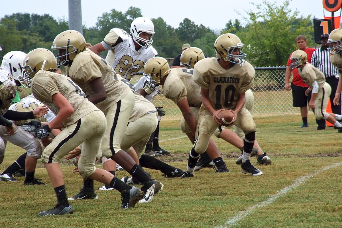 Image: Quarterback Tylan Wallace(10) takes the snap and then turns to handoff to one of his running backs.