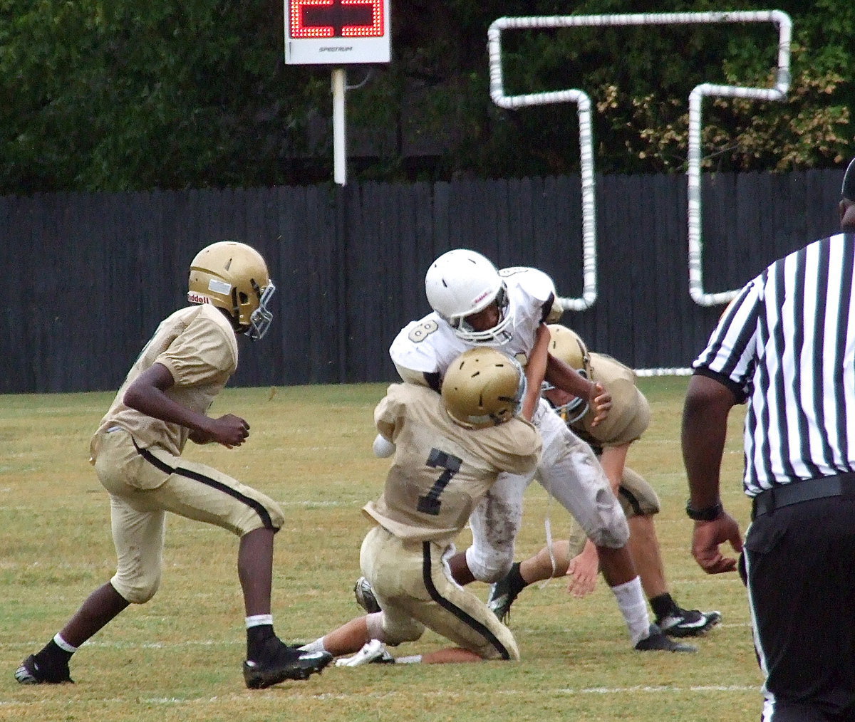 Image: Gary Escamilla(7) brings down a Hubbard back with help from Clay Riddle(60) and Chasston Wilson(9).