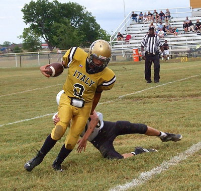 Image: Italy’s JV Gladiator, Joe Celis #2, slips past a Hubbard tackler to continue around the edge for positive yards.