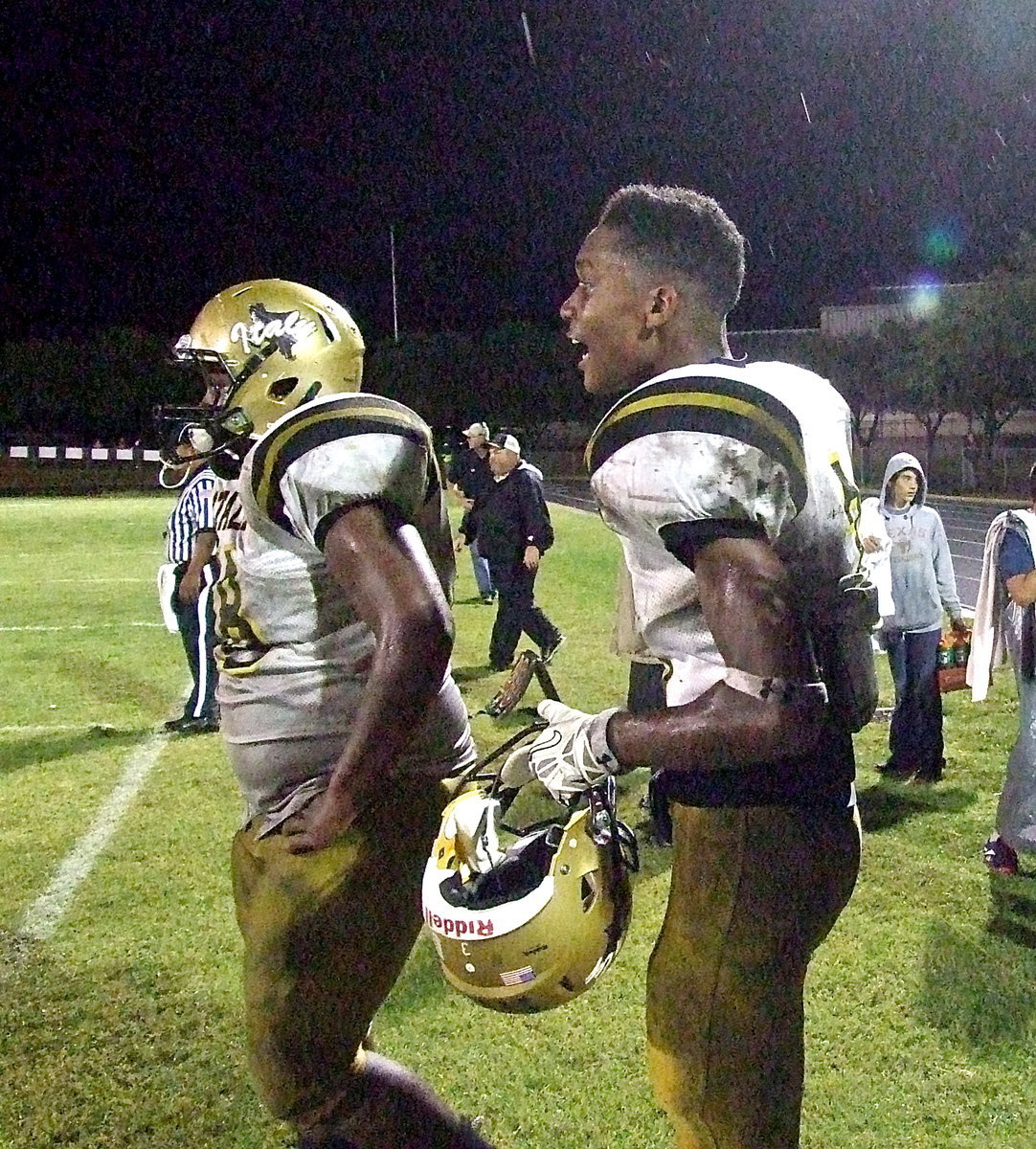 Image: The Gladiators poured it on during the first half of the “Mud Bowl” as seniors’ Trevon Robertson(3) and Darol Mayberry(58) try to pump up their teammates during a brief rest on Italy’s sideline.