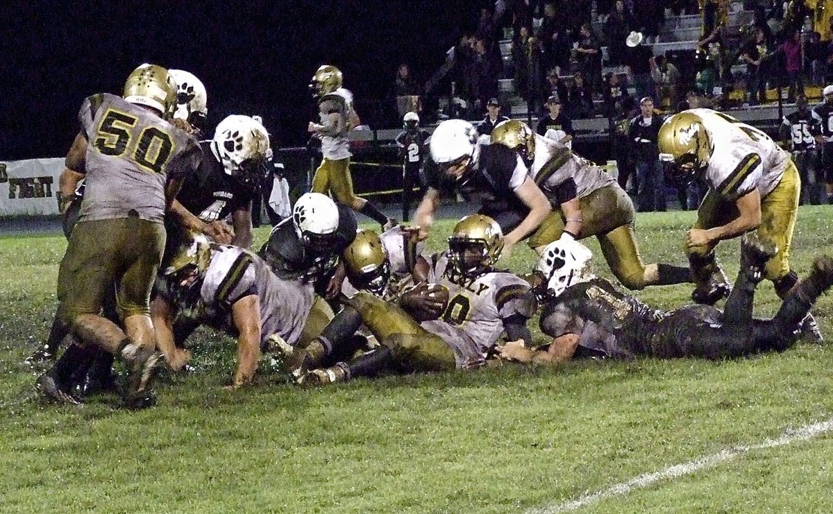 Image: Italy back TaMarcus Sheppard(10) gets dragged down to the ground during a muddy scrum.