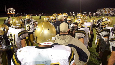 Image: Gladiator head coach Charles Tindol huddles with his offense before halftime.