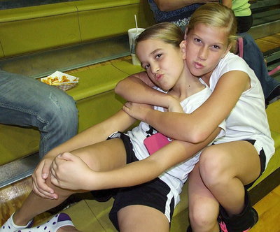 Image: Karley Nelson(8) and Karson Holley(5) chill in the stands after their game.