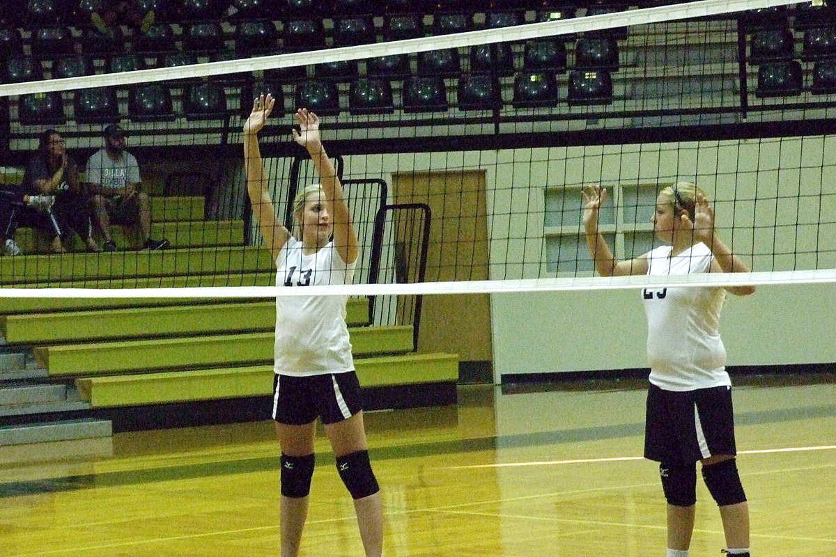 Image: Annie Perry(13) and Brycelen “ChaCha” Richards(23) strategize before the serve.