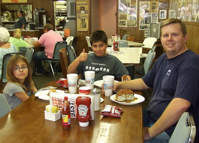 Image: Mike South, editor for the Italy Neotribune online newspaper and the IT manager for Monolithic, Inc., with his daughter Catie and son Mikey as they enjoy their meals to help raise money for the new camera.