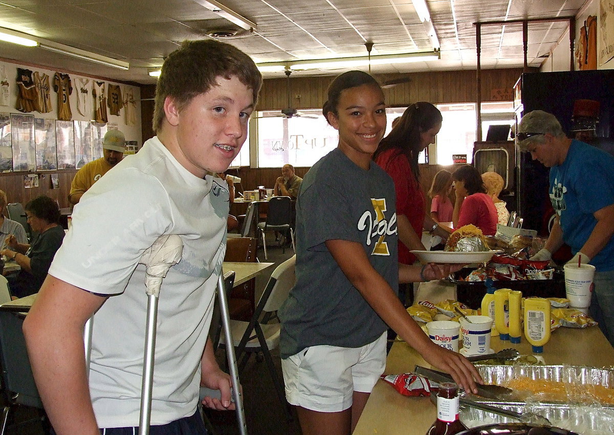 Image: John Escamilla, April Lusk and Amanda Connor get served their meal by DeeDee Hamilton.