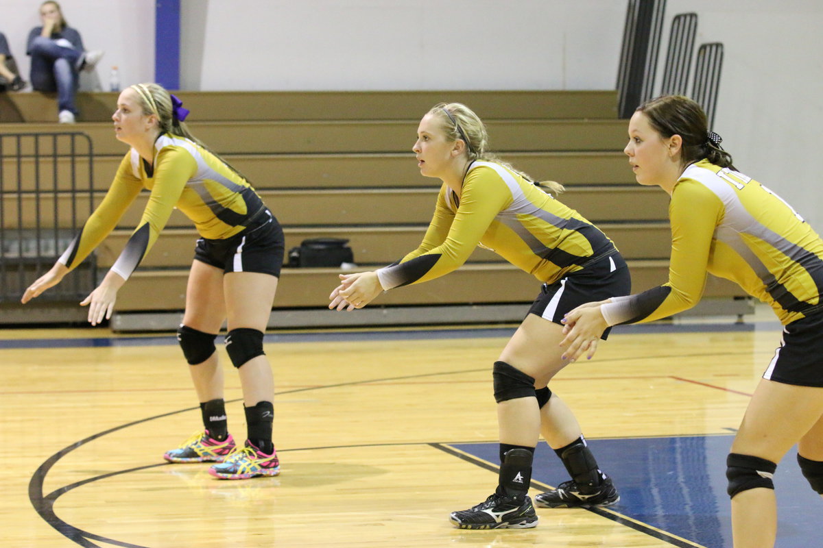 Image: Madison Washington(10), Jaclynn Lewis(15) and Bailey Eubank(1) settle in for the serve.