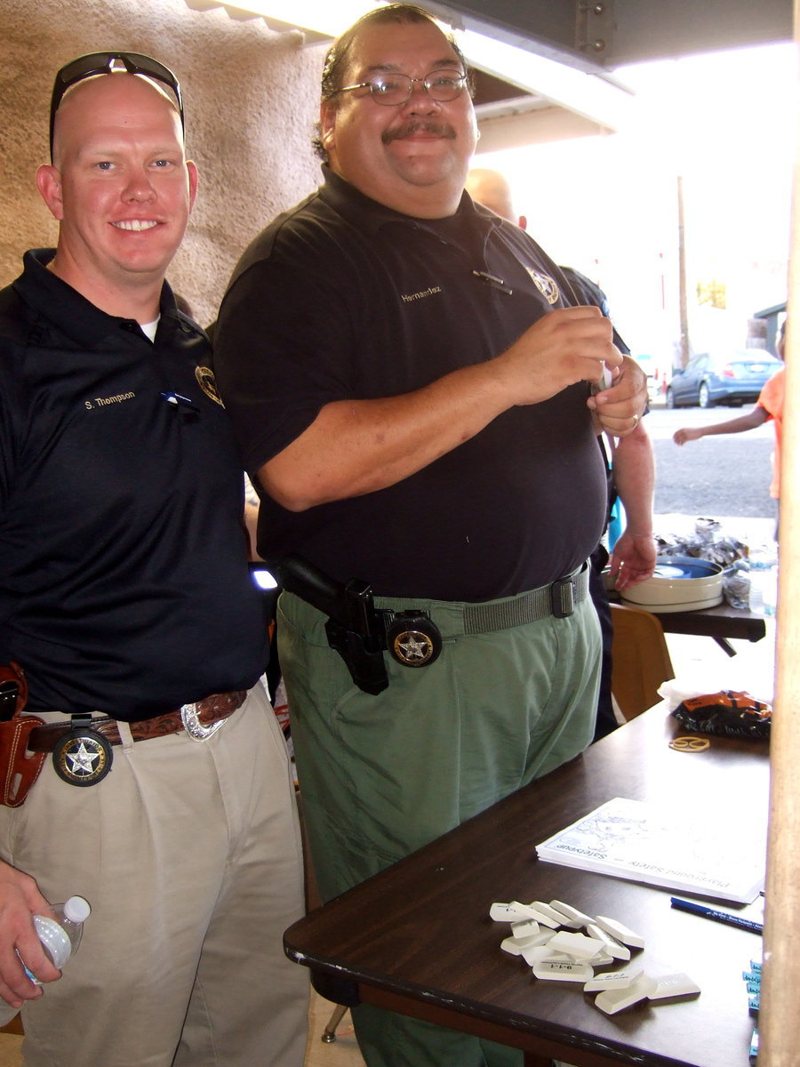 Image: Shane Thompson (investigator for the Sheriff’s office) and Deputy Rupert Hernandez (Sheriff’s office) are busy helping out at National Night Out.