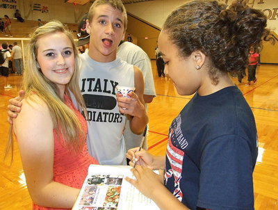 Image: Levi McBride gets brain freeze from his snow cone as Vanessa Cantu signs Kelsey Nelson’s yearbook.