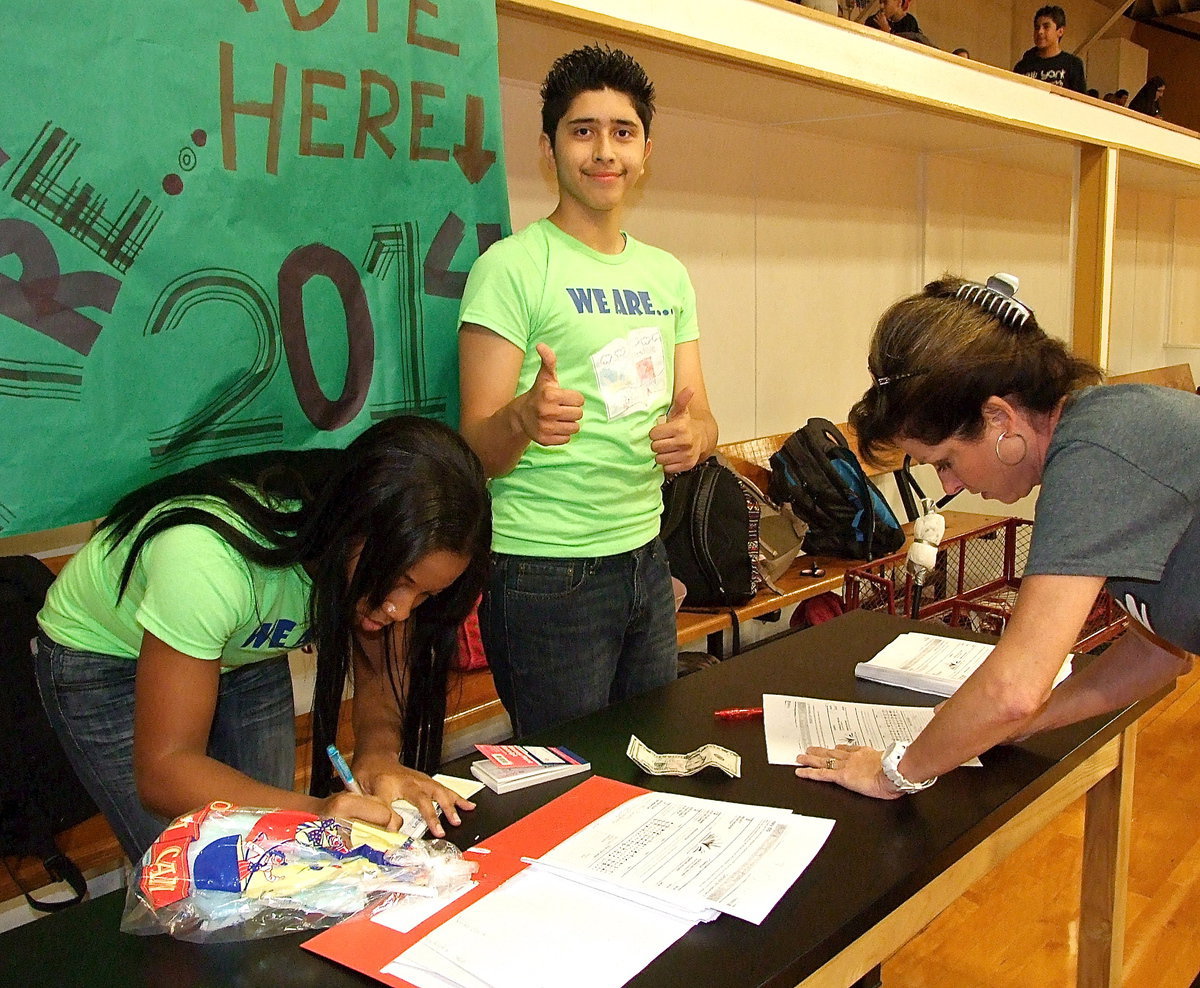 Image: Joseph Sage gives two thumbs up as fellow yearbook staffer Bernice Hailey helps Andi Windham order a 2013-2014 yearbook.