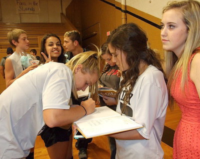 Image: Jaclynn Lewis signs Cassidy Childers yearbook with Kelsey Nelson looking on while Ashlyn Jacinto signs Reagan Cockerham’s yearbook. Hanging out in the background are Clayton Miller and Coby Bland.
