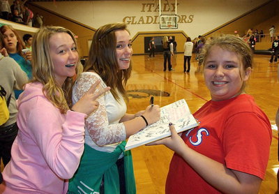 Image: Rachel Huskins vows for world peace while Sarah Levy signs Jill Varner’s yearbook.