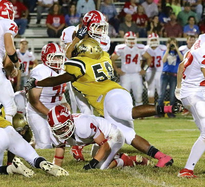 Image: Defensive lineman Darol Mayberry(58) overcomes a cut block to make a helmet to football tackle on a Hico runner.