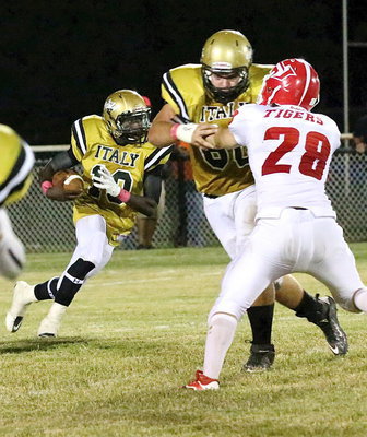 Image: Kevin Roldan(60) tries to control the edge for running back TaMarcus Sheppard(10) who cuts behind him.