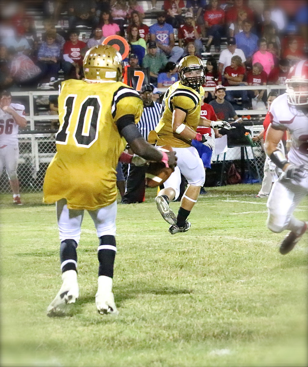 Image: TaMarcus Sheppard(10) tries to drop a pass off to Hunter Merimon(9) in the flat.