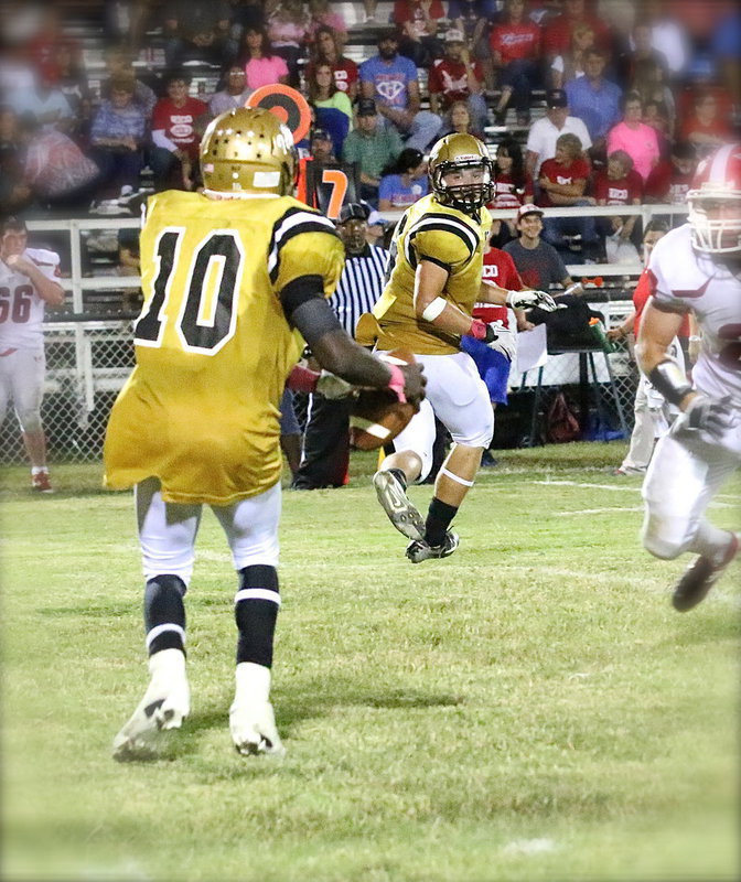 Image: TaMarcus Sheppard(10) tries to drop a pass off to Hunter Merimon(9) in the flat.