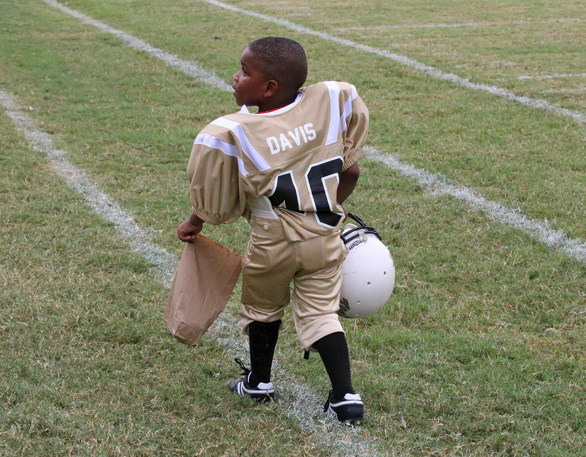 Image: Walking off the field with his snack bag after a hard game’s work is Charles Davis(40).