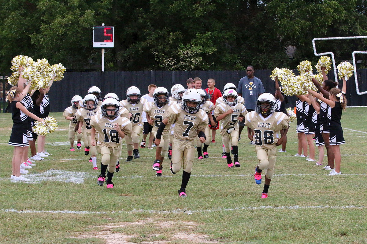 Image: The ground trembles as Chance Shaffer(18), Laveranues Green(7) and Darrin Jackson(88) lead the IYAA B-team Gladiators onto the field.