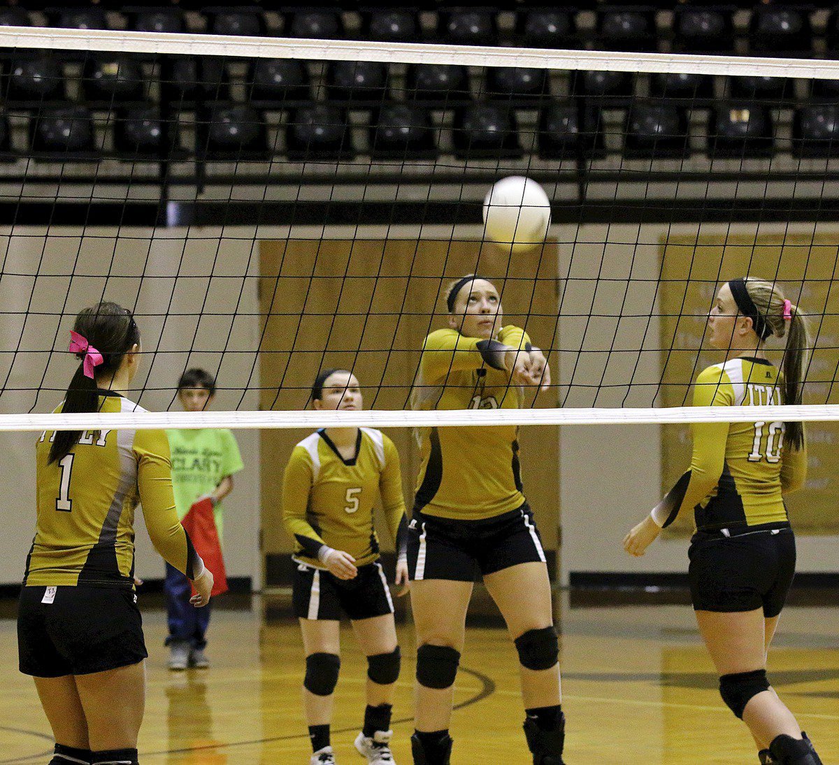 Image: Bailey Eubank(1), Tara Wallis(5) and Madison Washington(10) backup Jaclynn Lewis(15) as she bumps the ball up in the air.