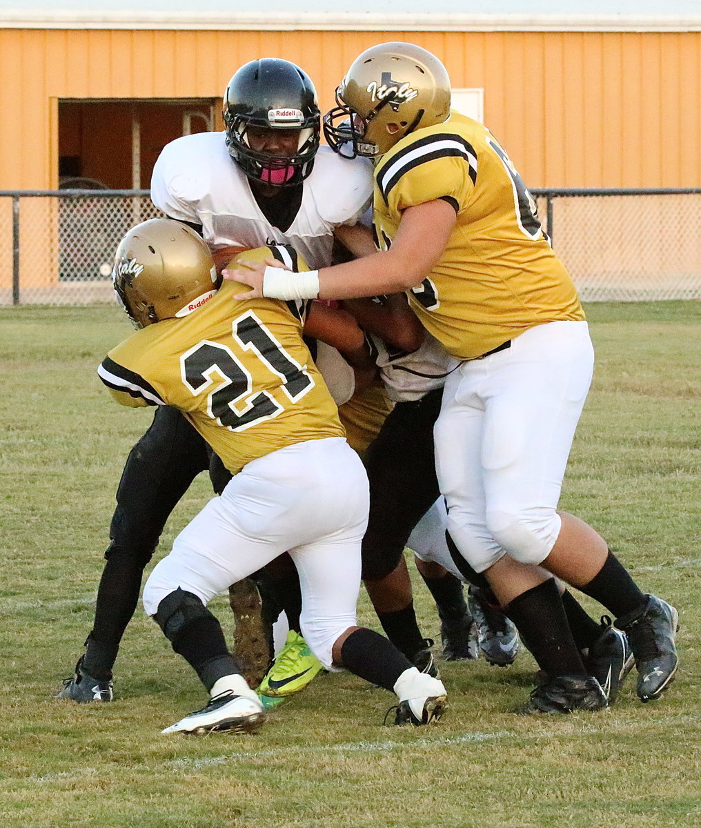 Image: Jorge Rodriguez(21) and Austin Pittmon help stop an Itasca runner in the Wampus Cat backfield.