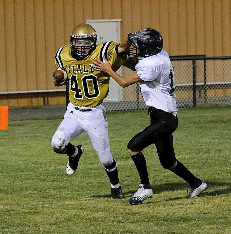 Image: Colton Grant(40) tries to stiff arm his way free from a clawing Wampus Cat.