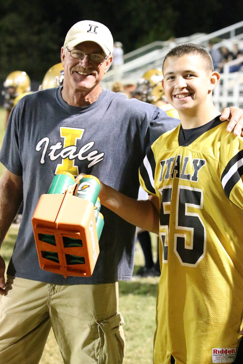 Image: Italy’s head coach Charles Tindol thanks JV Gladiator Austin Crawford(55) who helped with the water duties.