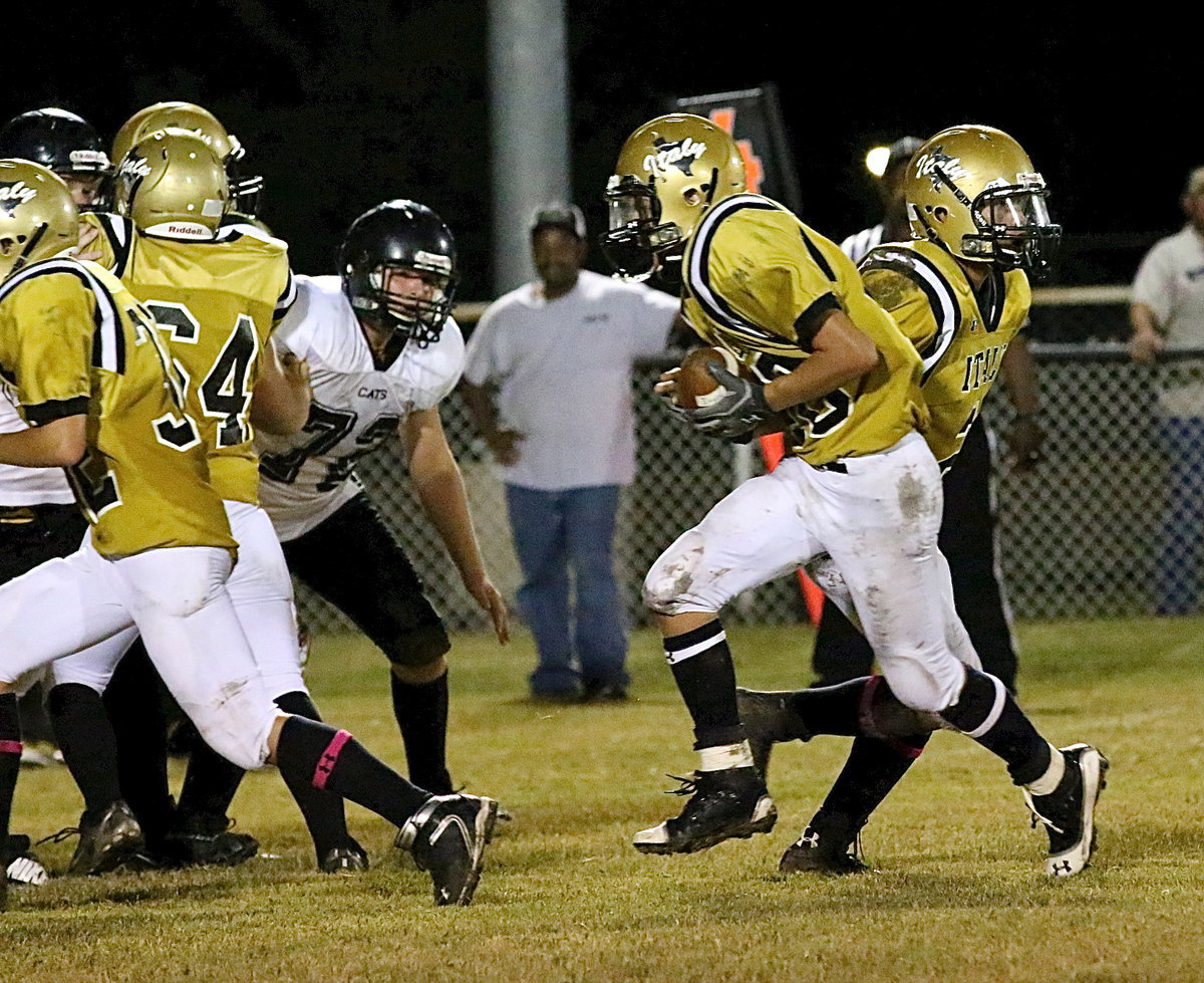 Image: Joe Celis(2) hands off to Colton Grant(40) who follows Eli Garcia(32) into the hole behind guard Elliott Worsham(54).