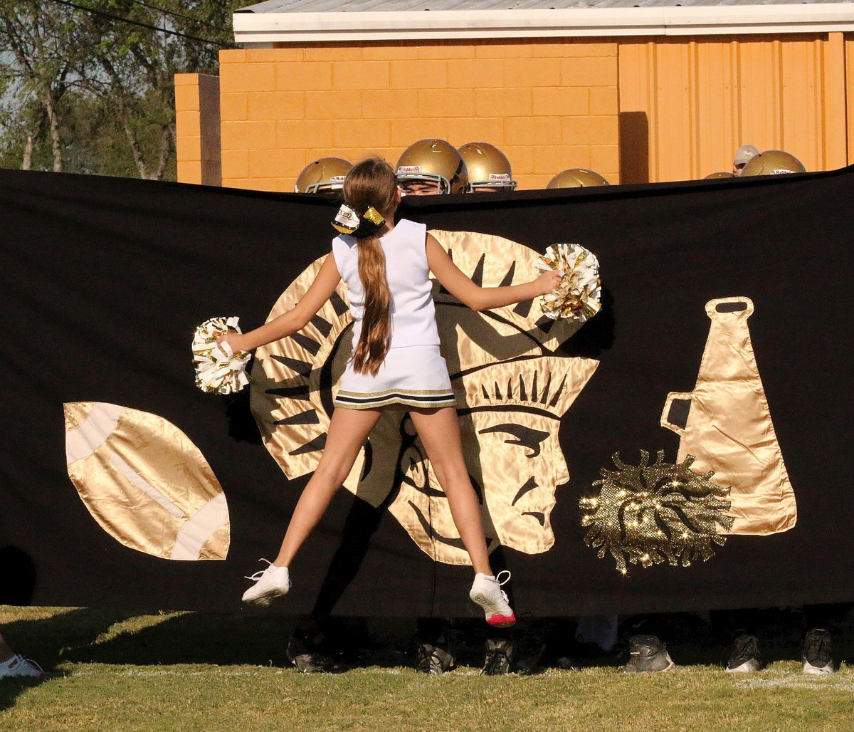 Image: Cheerleader Karley Nelson checks to see if the players or ready to take the field.