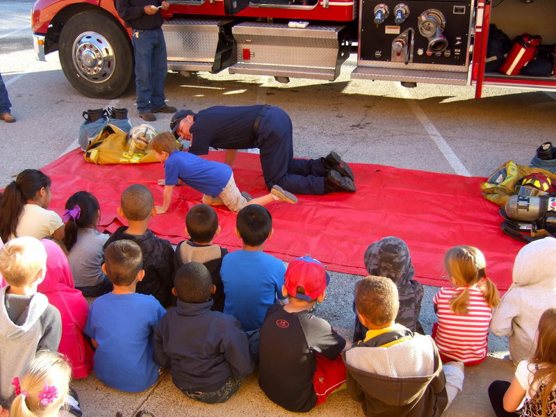 Image: Fireman Cate and a Stafford Elementary student are demonstrating crawling under the smoke.