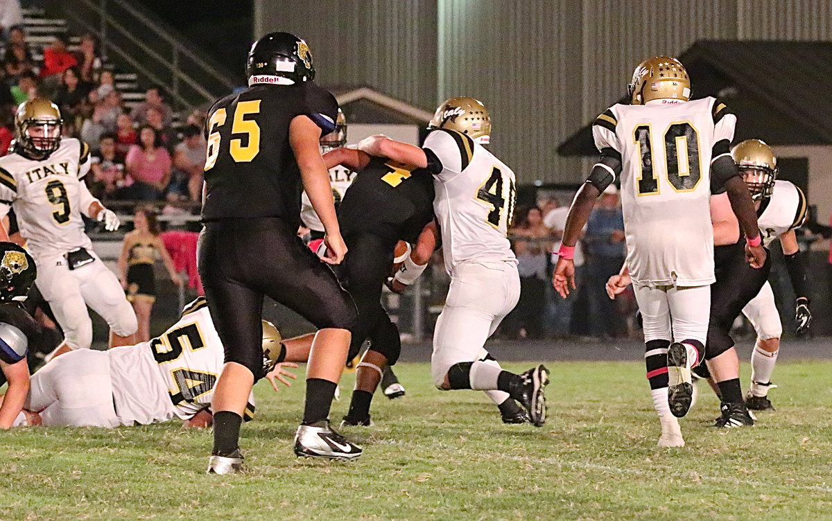 Image: Defensive end Bailey Walton(54) helps linebacker Coby Bland(40) secure a tackle for Italy.