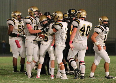 Image: Clayton Miller(6) is congratulated by his defensive teammates after the interception.