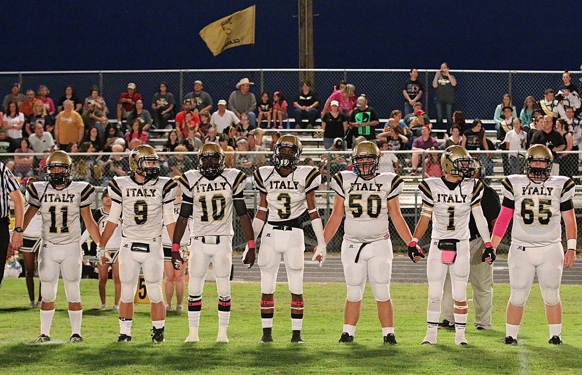 Image: Displaying team unity during the coin toss are (L-R) Tyler Anderson(11), Hunter Merimon(9), TaMarcus Sheppard(10), Trevon Robertson(10), Zain Byers(50), Levi McBride(1) and Tyler Vencill(65).