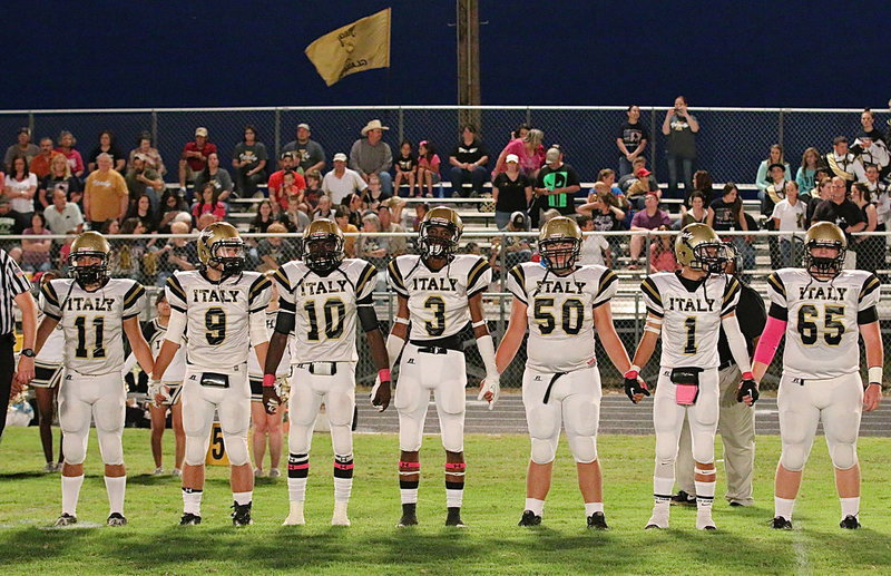Image: Displaying team unity during the coin toss are (L-R) Tyler Anderson(11), Hunter Merimon(9), TaMarcus Sheppard(10), Trevon Robertson(10), Zain Byers(50), Levi McBride(1) and Tyler Vencill(65).