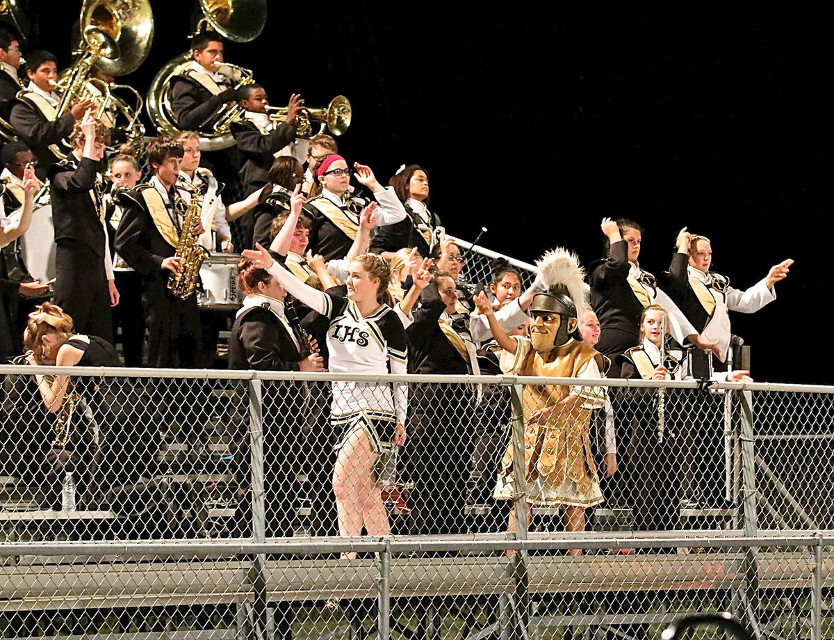 Image: Cheer captain Taylor Turner and Gladiator mascot Noeli Garcia join the band in raising their swords before the kick off.