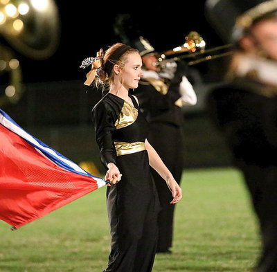 Image: Color Guard member Kayla Cunningham sports a smile while waving her flag during the halftime show.