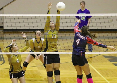 Image: Jaclynn Lewis(13) gets the block with teammates Halee Turner(4) and Madison Washington(10) nearby to help.