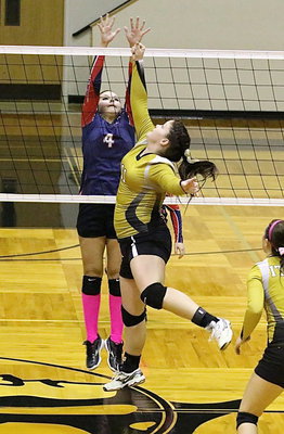 Image: Paige Westbrook(11) challenges Kopperl at the net and punches the ball over the Lady Eagle blocker.