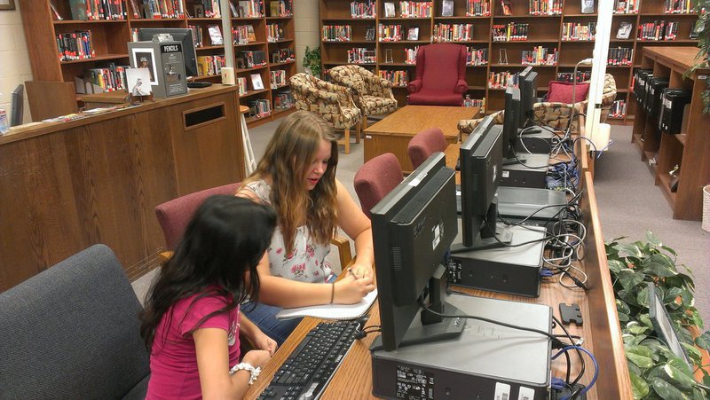Image: Tia Russell, a junior, is assisting Belina Silva, a 7th grader, with a math assignment.