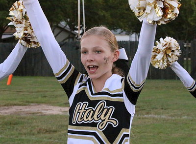 Image: Cheerleader Taylor Boyd welcomes Italy’s 8th grade football team onto the field.