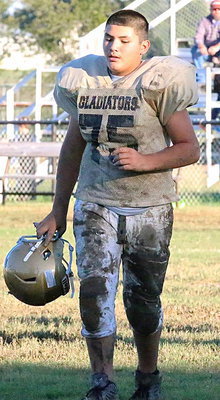 Image: Lineman Alex Garcia(75) is already caked in mud by halftime.