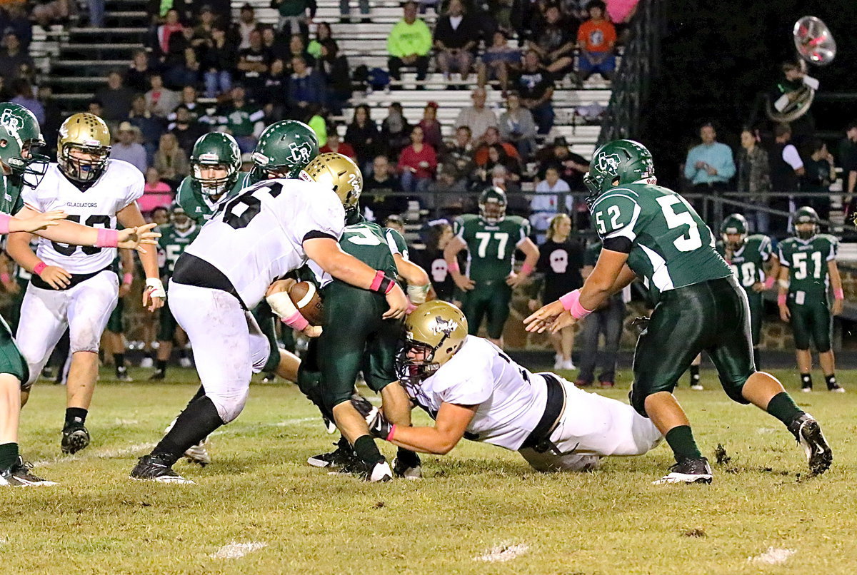 Image: Colin Newman(76) hits him low and John Byers(56) hits him high as both Gladiator defensive tackles combine for a takedown.