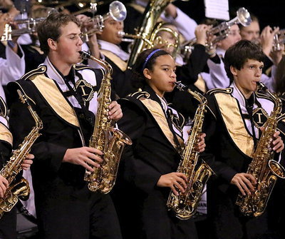Image: GRB members Joe Mack Pitts, April Lusk and Ty Hamilton play their saxophones in the stands.