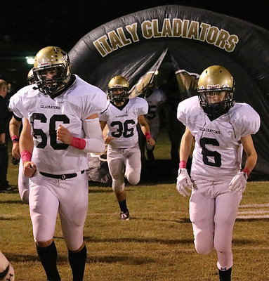Image: Gladiators Kyle Fortenberry(66), Tyler Anderson(36) and Clayton Miller(6) take the field to start the game against Crossroads.