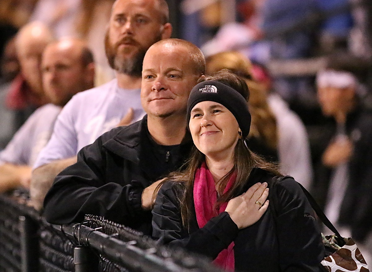 Image: Jennifer and Michael Chambers, and Richard Dabney show respect to our country’s flag before the kickoff.